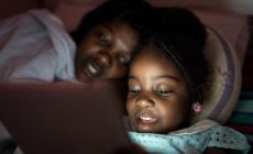 child looks at screen at night 